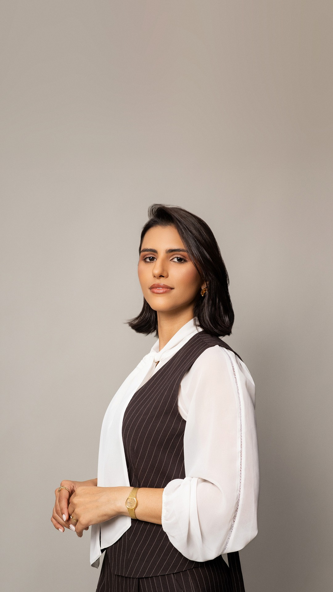 Yasmin Rabelo Gomes, fundadora da Rágora, de colete risca de giz, olhando para a câmera
